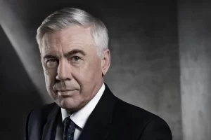 Carlo Ancelotti sorrindo com a camisa da Seleção Brasileira no anúncio oficial.