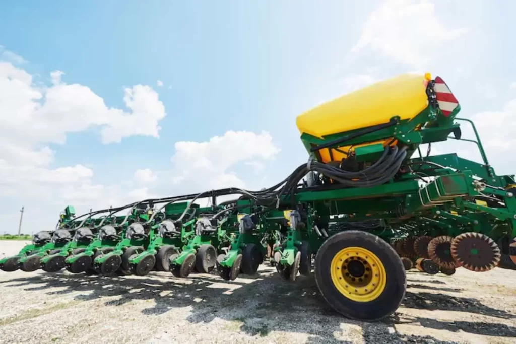 Alta na Importação de Fertilizantes Motor da Safra de Inverno Aquece 1 Trator aplicando fertilizante granulado em lavoura de milho safrinha (safra de inverno), mostrando a aplicação de insumos importados no campo.