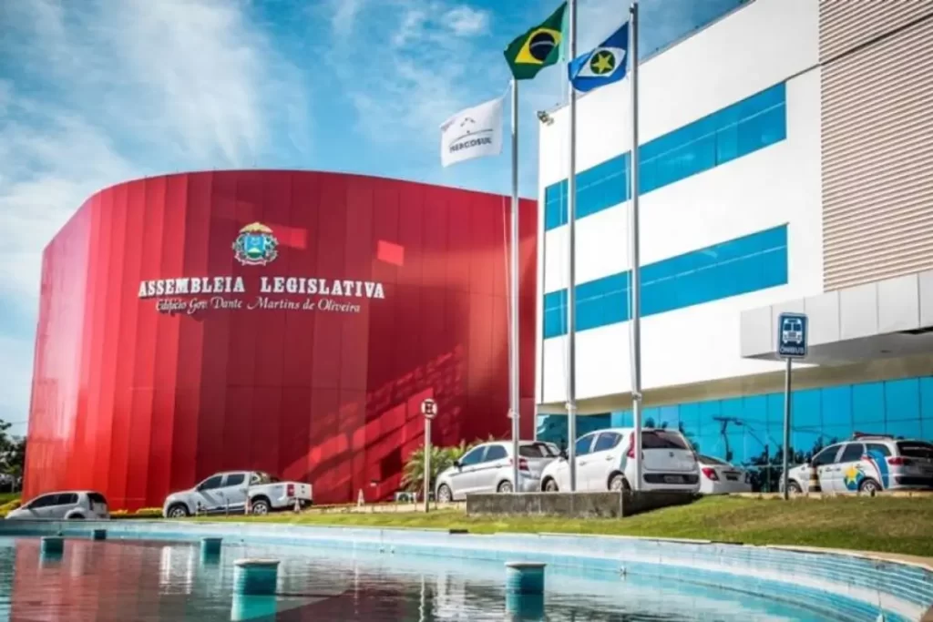 Desvio de R$ 308 milhões PF mira fundos ligados à família Mendes após denúncia 1 Fachada iluminada da Assembleia Legislativa de Mato Grosso com notas de real simbolizando o desvio de R$ 308 milhões
