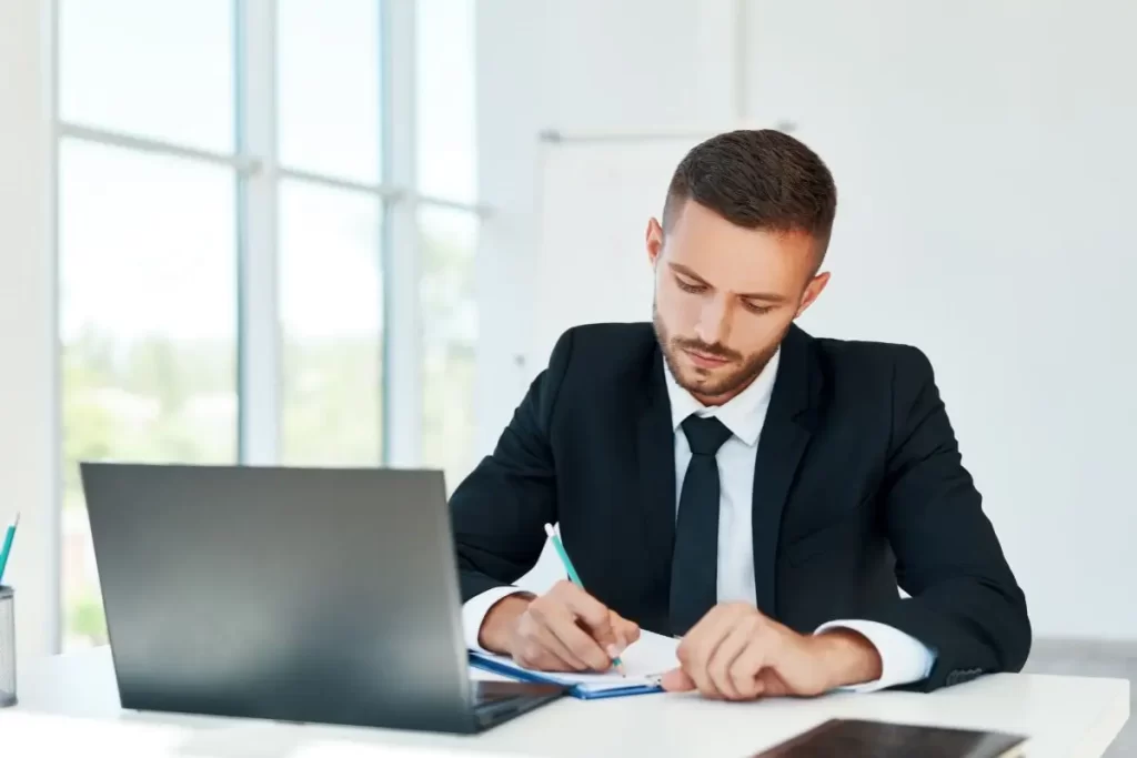 Banco Central Aponta para Juros Mais Baixos e Queda na Inflação em 2025 2 Pessoa assinando contrato de financiamento com taxas de juros reduzidas, representando a projeção de juros mais baixos em 2025.