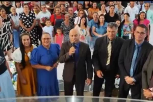 Pastor Sidnei Alexandre falando ao microfone em culto da Assembleia de Deus em Rondonópolis, com fiéis reunidos em celebração e comunhão.