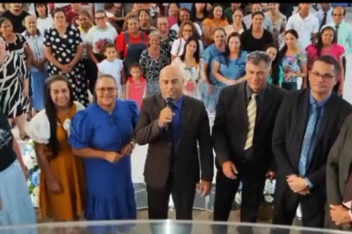 Pastor Sidnei Alexandre falando ao microfone em culto da Assembleia de Deus em Rondonópolis, com fiéis reunidos em celebração e comunhão.