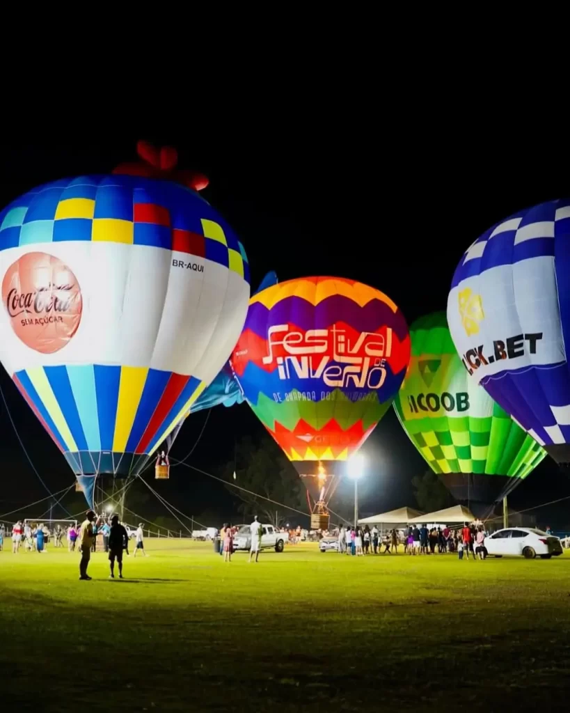 Descubra 5 eventos que vão agitar Chapada dos Guimarães em 2025 7 balões de ar quente sobrevoando paredões vermelhos ao nascer do sol na Chapada dos Guimarães