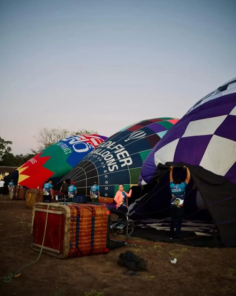 Descubra 5 eventos que vão agitar Chapada dos Guimarães em 2025 6 balões de ar quente sobrevoando paredões vermelhos ao nascer do sol na Chapada dos Guimarães