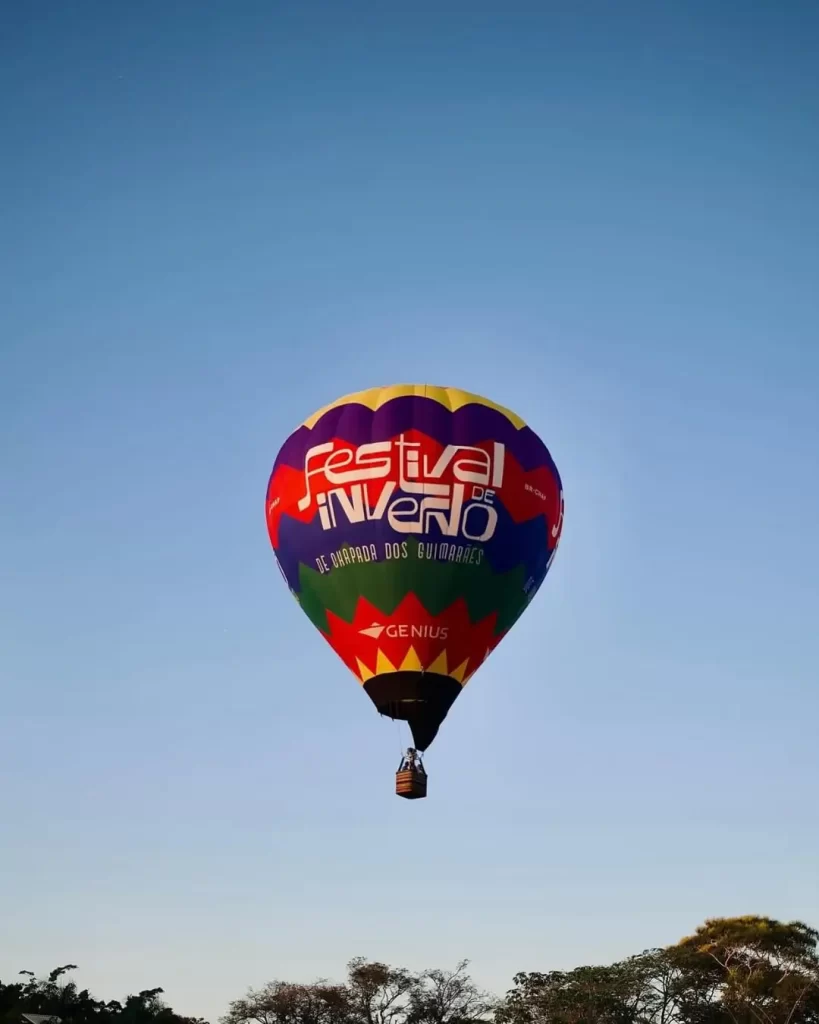 Descubra 5 eventos que vão agitar Chapada dos Guimarães em 2025 5 balões de ar quente sobrevoando paredões vermelhos ao nascer do sol na Chapada dos Guimarães