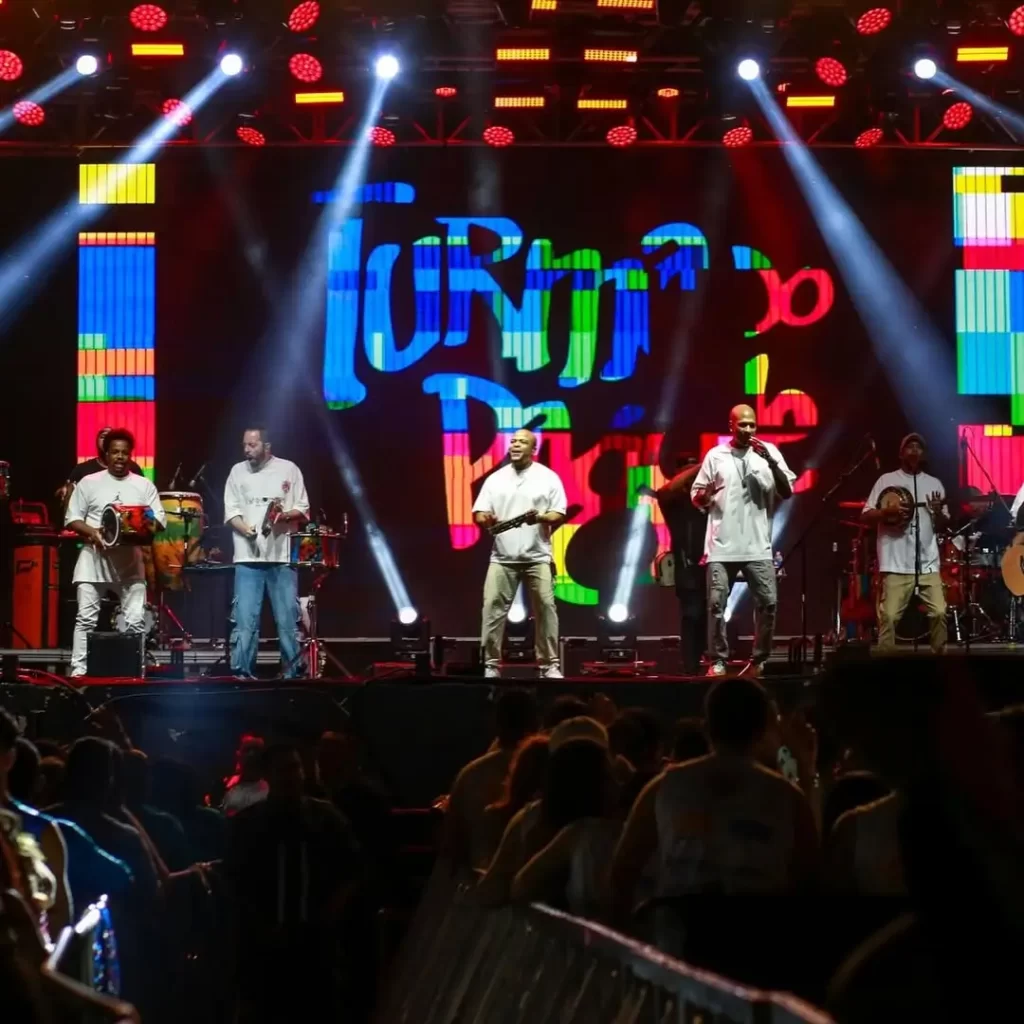 Descubra 5 eventos que vão agitar Chapada dos Guimarães em 2025 3 foliões fantasiados dançando ao som de trio elétrico no Carnaval Chapada Folia 2025