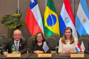 ministro da saúde do Brasil em reunião internacional com bandeiras do Mercosul ao fundo