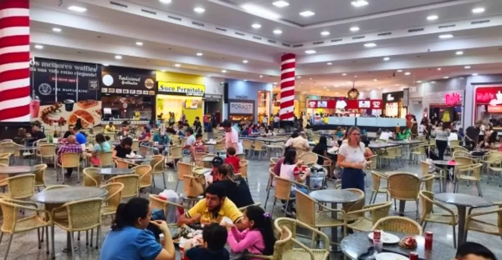 Praça de alimentação do Rondon Plaza Shopping em Rondonópolis, com restaurantes e mesas cheias de visitantes.