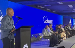 Gutemberg Carvalho Silveira e Pierre Patriat lideram representantes na maior feira de pecuária de corte do Brasil, banner de sementes de pastagem ao fundo”