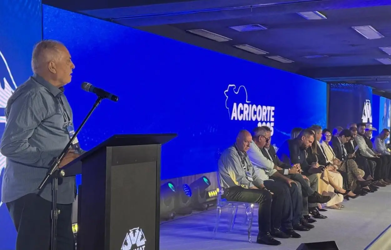 Gutemberg Carvalho Silveira e Pierre Patriat lideram representantes na maior feira de pecuária de corte do Brasil, banner de sementes de pastagem ao fundo”