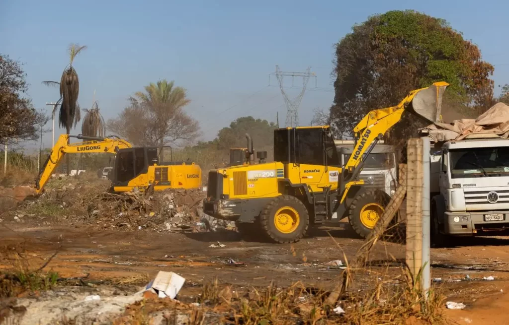 Pá carregadeira e escavadeira removem entulho de um bolsão de lixo em Rondonópolis durante operação da prefeitura