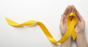 Fita amarela dobrada no formato do laço símbolo do Setembro Amarelo, posicionada em destaque para ilustrar a campanha de conscientização e valorização da vida.